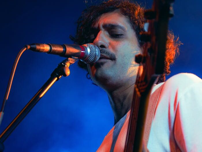 Engaging live concert shot featuring a guitarist performing under vibrant blue lighting.