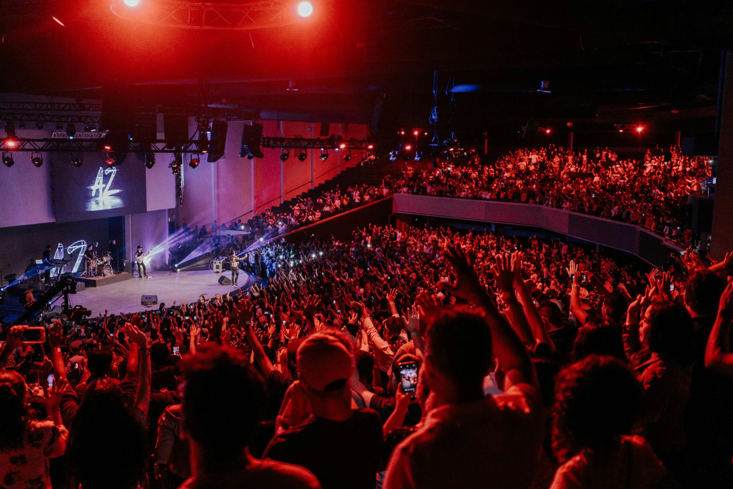 Vibrant live concert scene with an excited crowd under dramatic stage lighting.